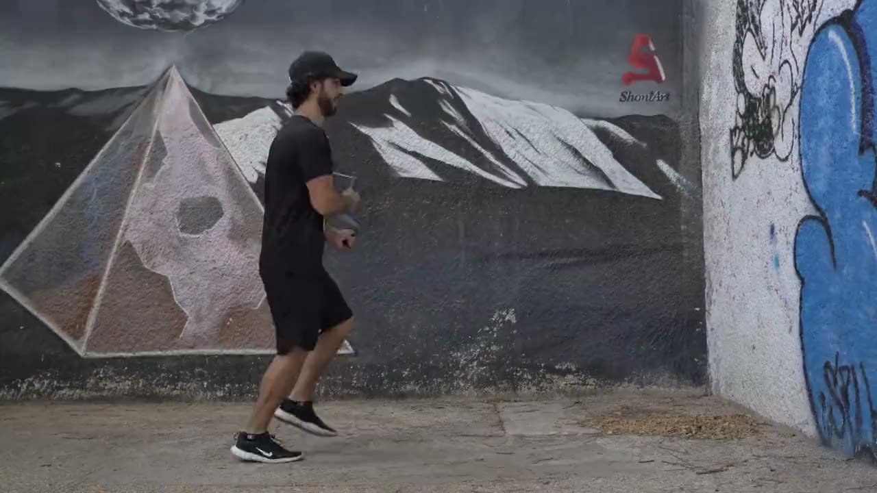 מתאמן אתלטיגו קופץ בחבל קפיצה במעבר תת קרקעי עם ציור קיר של פירמידה